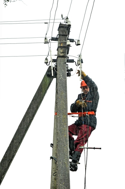 Electricista elimina un accidente en un poste de línea de transmisión de energía bajo fuertes lluvias.