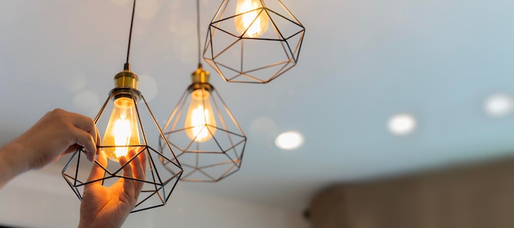 Foto un electricista está instalando focos en el techo handyman eligiendo entre ahorro de energía y lámpara incandescente barata mientras cambia la luz