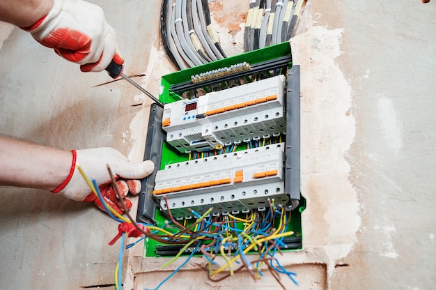 Un electricista instalando los fusibles en la caja de interruptores.