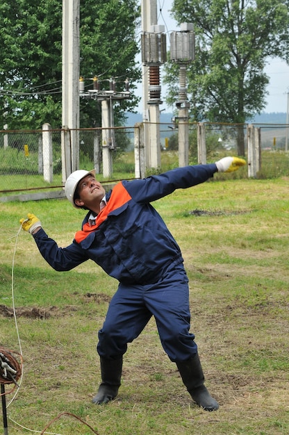 Un electricista intenta conectar a tierra los cables de una línea eléctrica aérea