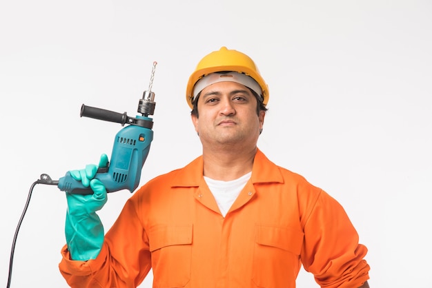 Electricista o ingeniero guapo asiático indio en acción con sombrero de seguridad amarillo aislado