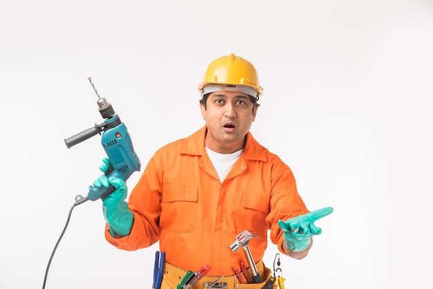 Electricista o ingeniero guapo asiático indio en acción con sombrero de seguridad amarillo aislado