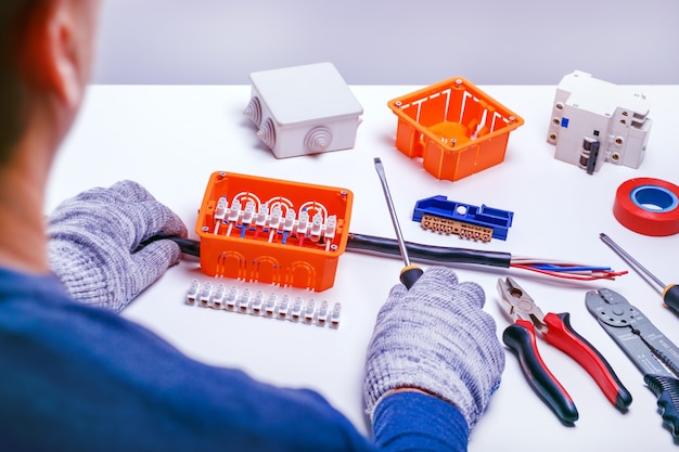 Electricista reparando cuadro eléctrico. reparacion de equipos electricos. herramientas eléctricas y componentes para servicio. pequeños negocios