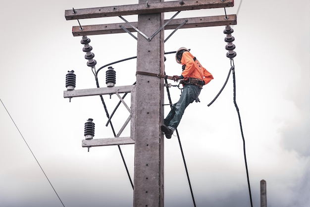 Los electricistas se suben a postes eléctricos para instalar y reparar líneas eléctricas.