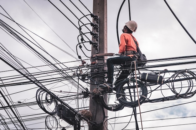 Los electricistas se suben a postes eléctricos para instalar y reparar líneas eléctricas.