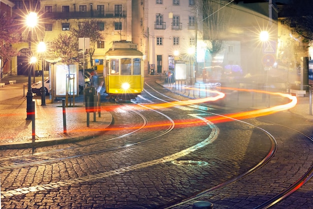 Eléctrico amarelo 28 em Alfama à noite Lisboa Portugal