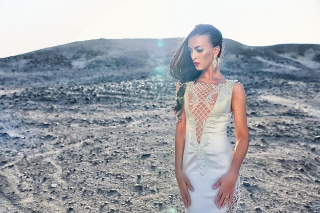 Elegância e modelo de moda. menina de vestido no deserto ensolarado. noiva e cerimônia de casamento. moda para casamentos e salão de beleza. mulher de vestido branco em dunas de areia.