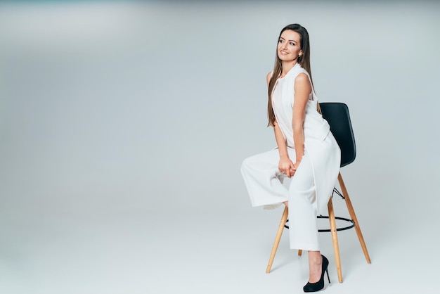 Elegancia hermosa modelo vestida de blanco Bastante jovencita en tela blanca posando