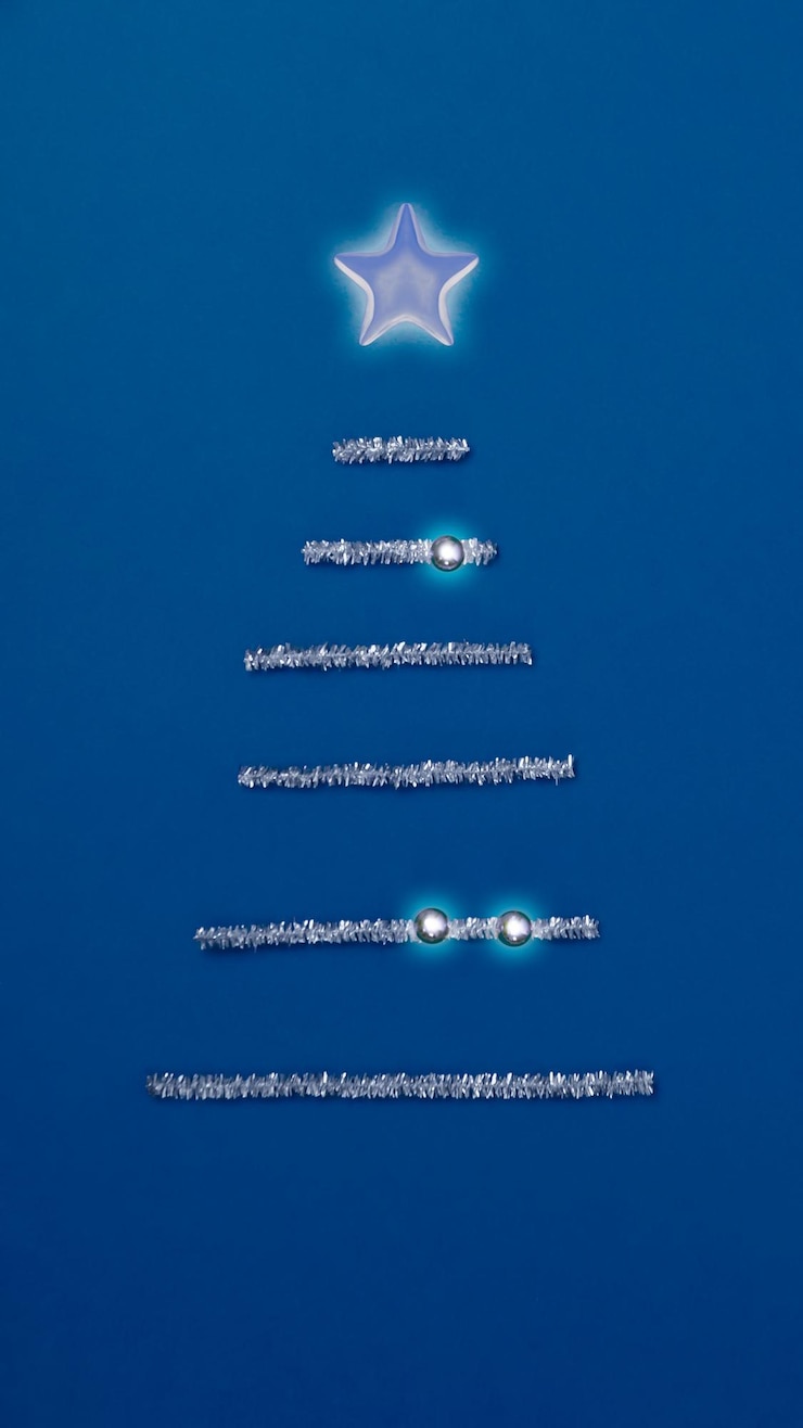 Foto elegancia y sencillez. fondo minimalista azul real. pino plateado y estrella brillante. las pequeñas bolas de luz son muy festivas y efectivas. la belleza y el brillo le dan una nota especial a las vacaciones navideñas.