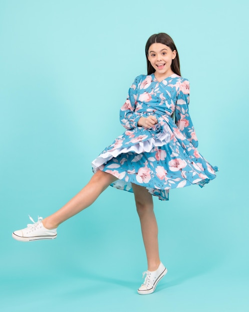Elegante adolescente niño niña en vestido de moda Chica en vestido de algodón aislado sobre fondo azul Emocionado adolescente asombrado y alegre emociones