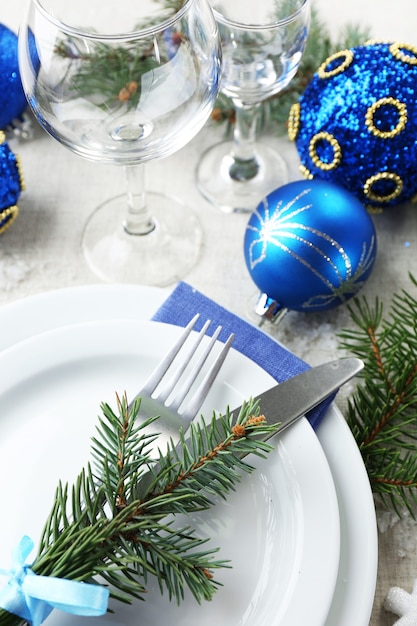 Elegante ajuste de la tabla de Navidad en azul y blanco sobre fondo de mantel gris