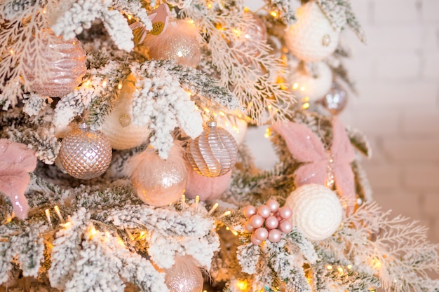 Elegante árbol de Navidad con adornos de color rosa y blanco.