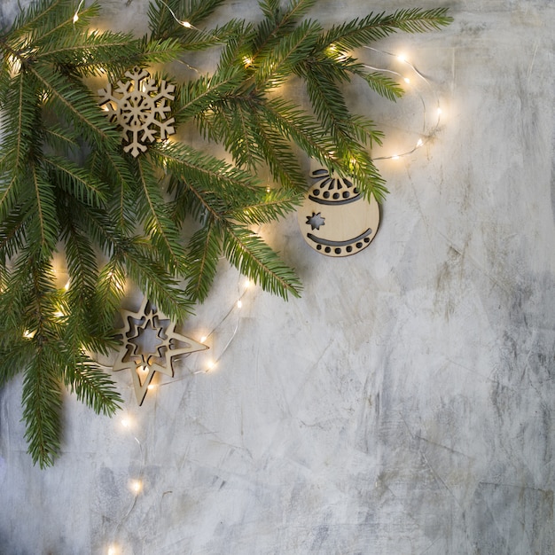 Elegante árbol de Navidad hecho a mano de madera sobre fondo gris con luces brillantes.