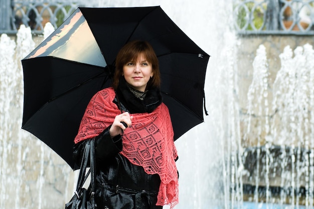 Elegante y atractiva mujer sonriente joven caminando por la calle en traje de otoño bufanda de punto rojo estilo de moda de humor feliz