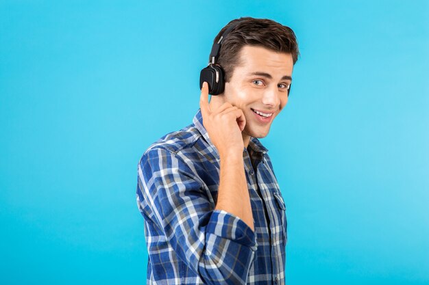 Elegante atractivo joven guapo escuchando música con auriculares inalámbricos