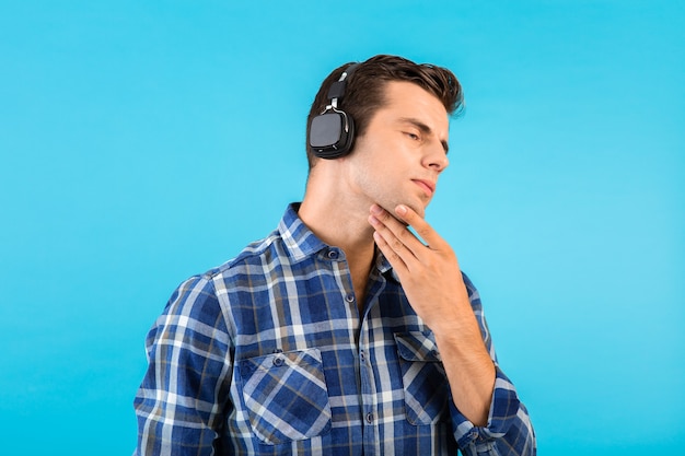 Elegante atractivo joven guapo escuchando música con auriculares inalámbricos