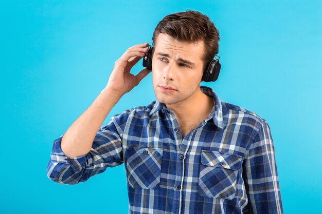 Elegante atractivo joven guapo escuchando música con auriculares inalámbricos