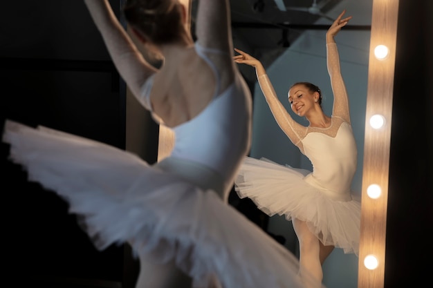 Elegante bailarina en vestido blanco bailando en studio