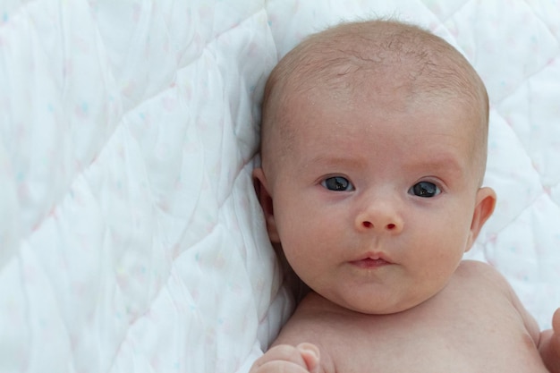 un elegante bebé recién nacido de dos meses descansa en su cuna, relajado