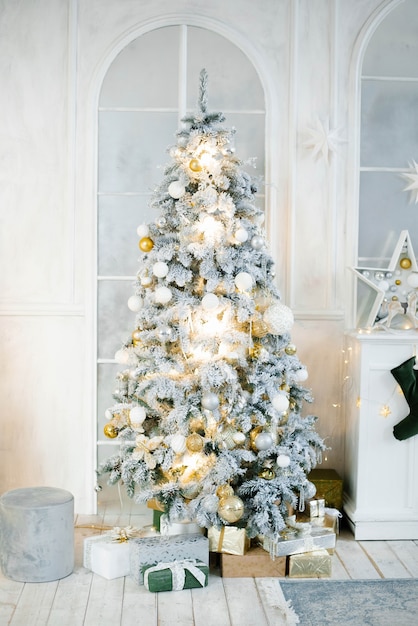 Elegante bela árvore de Natal prateada com balões brancos e dourados na clássica sala de estar