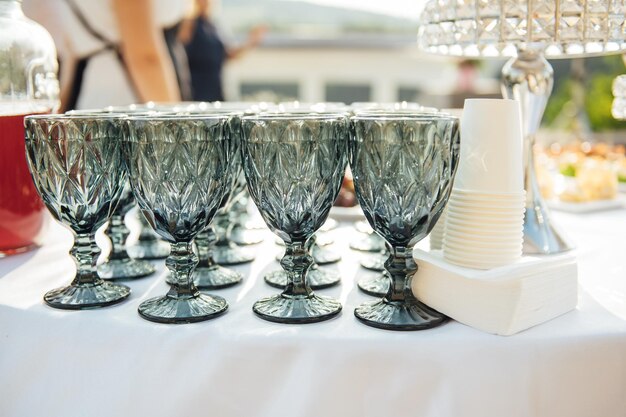 Elegante blaue Gläser ohne Sekt stehen in Reih und Glied neben Canapés und Häppchen auf malerischem Hintergrund.