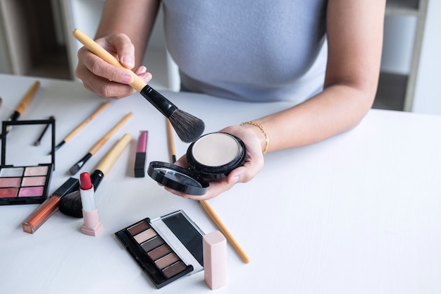 Elegante blogger de belleza femenina que muestra pruebas de cosméticos de belleza usando productos de maquillaje, cosméticos y productos de venta.