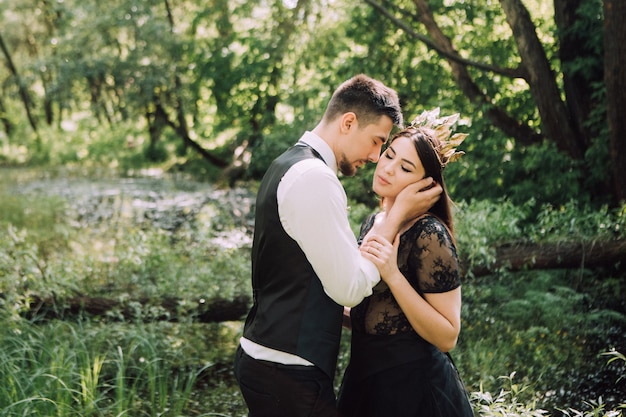 Elegante Braut und Bräutigam, die zusammen draußen an einem Hochzeitstag aufwerfen