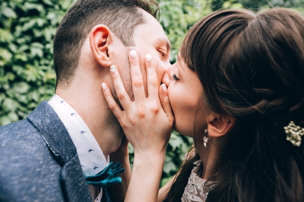 Elegante Braut und Bräutigam, die zusammen draußen an einem Hochzeitstag aufwerfen