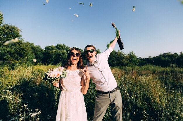 Elegante Braut und Bräutigam, die zusammen draußen an einem Hochzeitstag aufwerfen