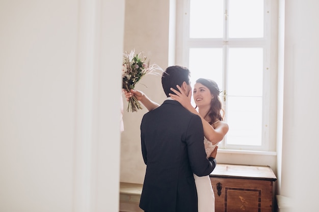 Foto elegante braut und bräutigam, die zusammen draußen aufwerfen