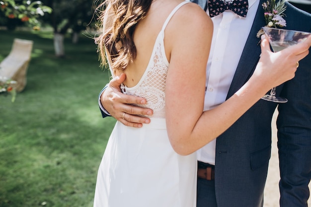 Foto elegante braut und bräutigam, die zusammen draußen aufwerfen