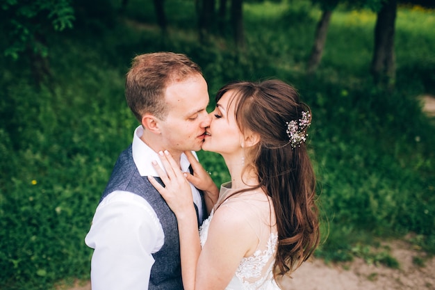 Elegante Braut und Bräutigam posieren zusammen im Freien an einem Hochzeitstag