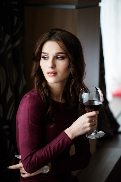 Elegante brünette Dame mit Glas Rotwein im Restaurant