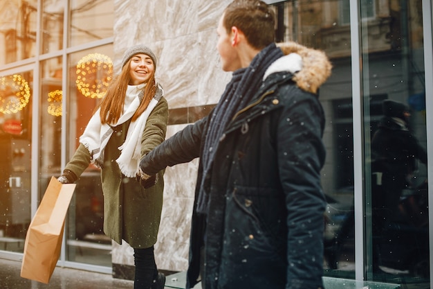 elegante casal apaixonado andando na cidade de primavera com sacos de compras