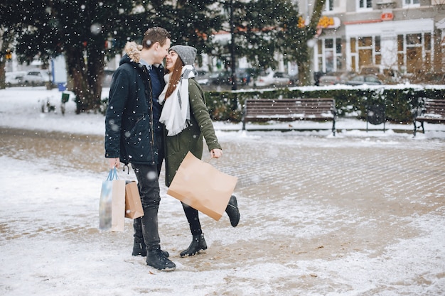 elegante casal apaixonado andando na cidade de primavera com sacos de compras
