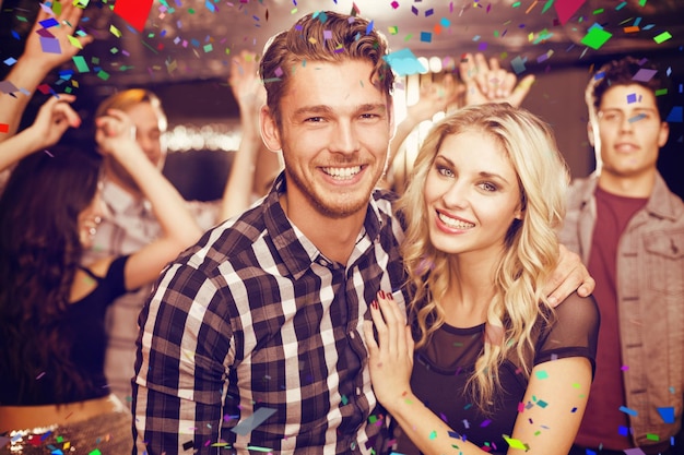 Elegante casal sorrindo e dançando juntos contra cores voadoras