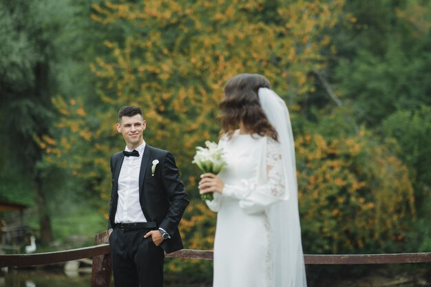 Elegante casamento europeu ao pôr do sol. Casal feliz na floresta na natureza.