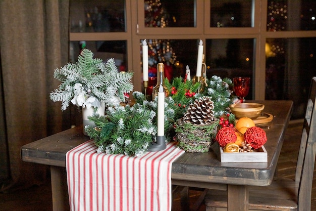 Elegante cenário de mesa de jantar de natal Decoração de velas de mesa de natal ramos de zimbro e guardanapos placas de madeira decorações de ano novo na sala de estar estilo country