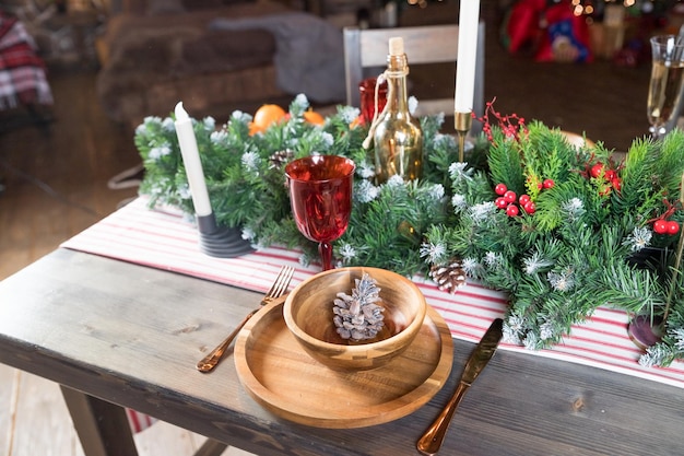 Foto elegante cenário de mesa de jantar de natal decoração de velas de mesa de natal ramos de zimbro e guardanapos placas de madeira decorações de ano novo na sala de estar estilo country