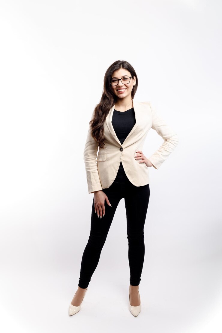 Elegante chica morena con chaqueta color crema y zapatos de tacones altos