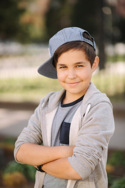 Elegante colegial con gorra azul posando afuera para una foto