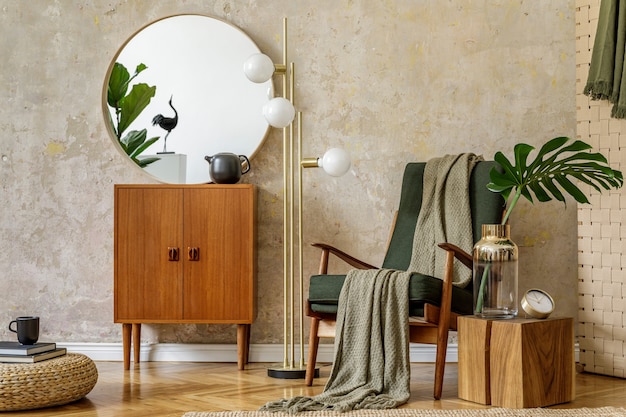Elegante composición del interior de la sala de estar con sillón de diseño, lámpara, puf de ratán, inodoro, hojas tropicales, cuadros, alfombras, espejos y elegantes accesorios presonales en concepto retro moderno.