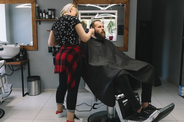 Elegante corte de pelo de peluquería de cliente en peluquería.