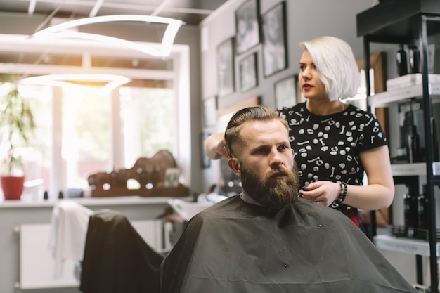 Elegante corte de pelo de peluquería de cliente en peluquería.