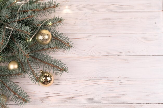 Elegante cubo de juguetes dorados de Navidad en madera blanca y ramas de árboles de Navidad