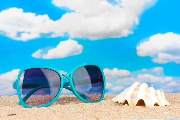 Elegante Damensonnenbrille mit Muschel am Strand