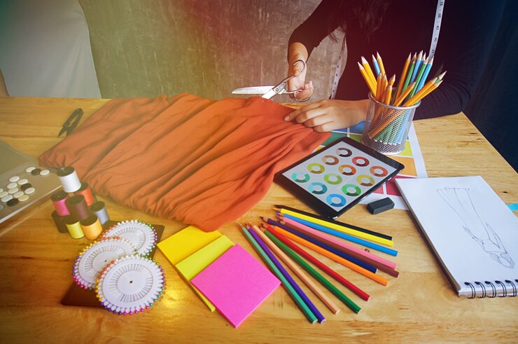 Foto elegante diseñador de moda tela de corte de nueva colección en el taller. concepto de diseño creativo.