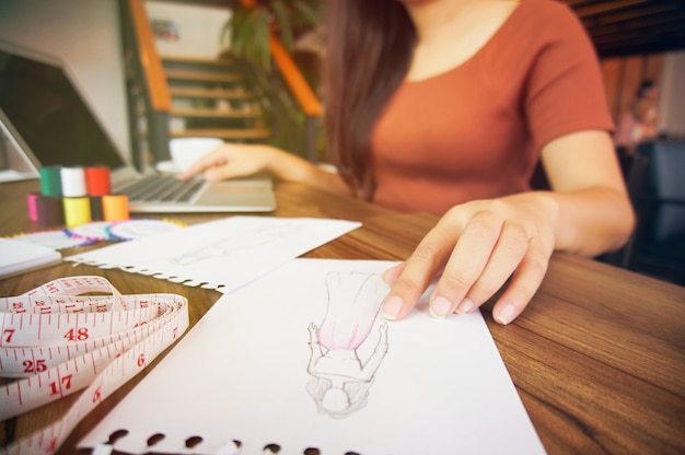 Elegante diseñador de moda de trabajo como boceto de la nueva colección en el taller. Concepto de diseño creativo