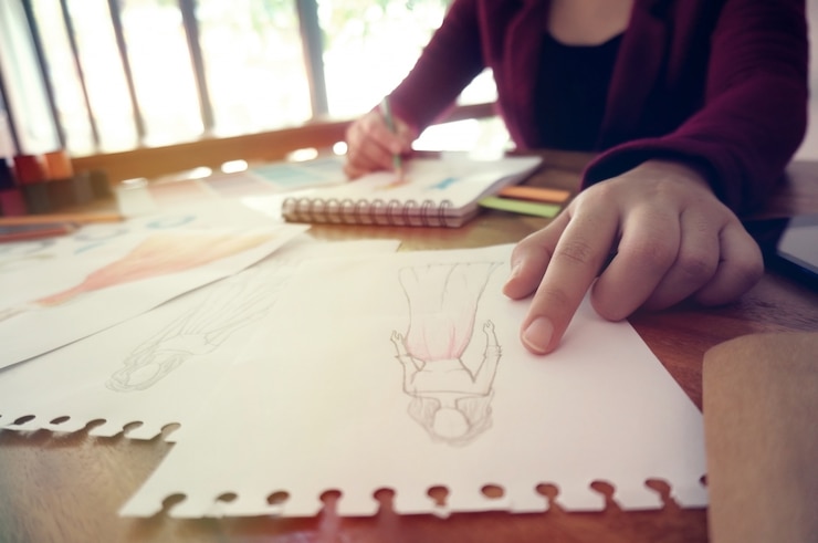 Foto elegante diseñador de moda de trabajo como boceto de la nueva colección en el taller. concepto de diseño creativo