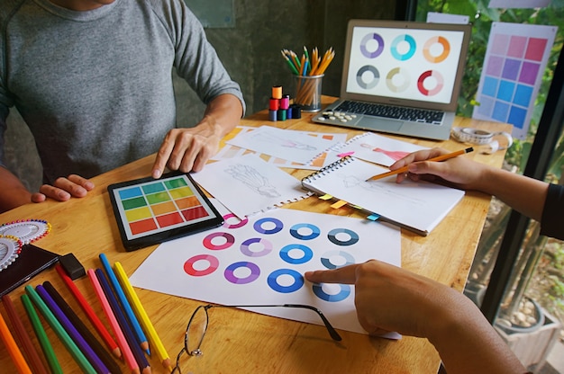 Foto elegante diseñador de moda de trabajo como boceto de la nueva colección en el taller. concepto del diseño creativo.